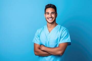 Wall Mural - Portrait of a smiling happy male medical doctor or nurse standing isolate on blue background, Medical concept.