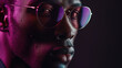 Hombre negro con gafas mirando a la camara, con reflejos de luz de colores