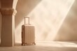 a beige colored small cabin sized suitcase with wheels standing in front of a sunny sunlit mediterranean off-white. Minimalistic vacation traveling concept