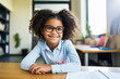 Smart girl with glasses sitting at her school desk