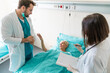 © Dorde - Male and female doctor visiting senior woman in hospital ward writing a report, talking, explaining medical procedure, discussing pre operating plan.
