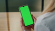 © stockbusters - Lady looking green display phone close up. Woman hands holding mockup cellphone