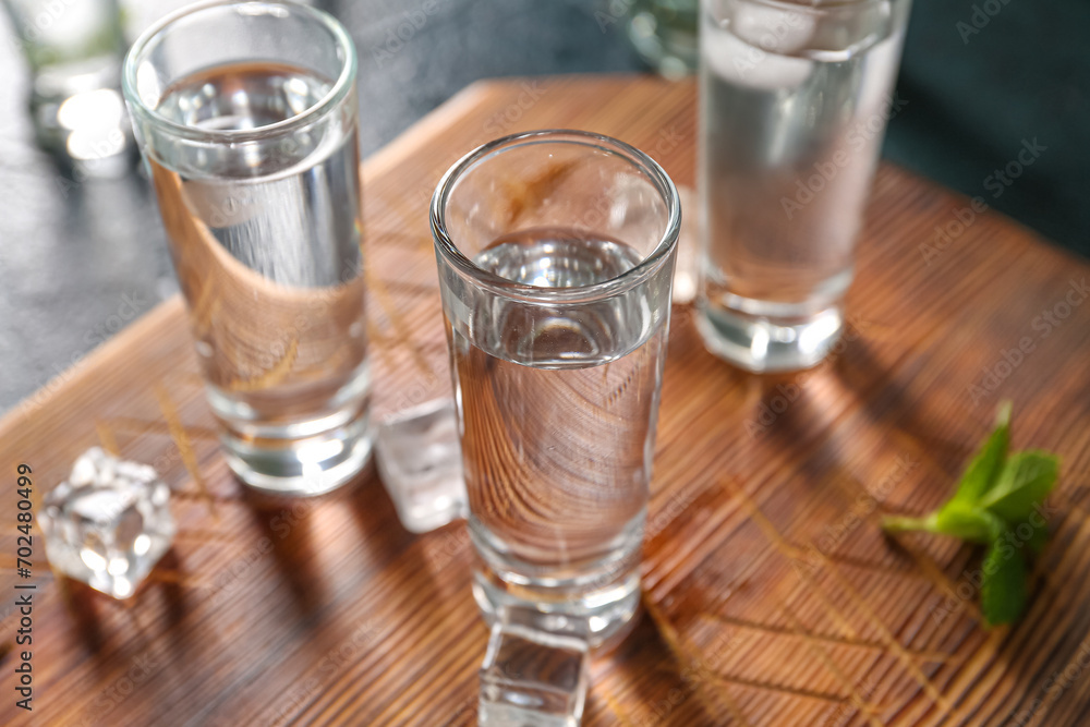 Glasses of cold vodka on black background