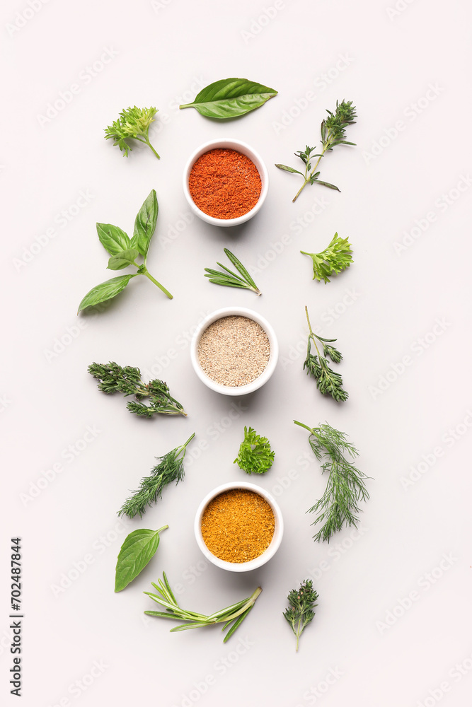 Composition with fresh herbs and different spices on light background