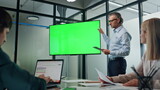 Fototapeta  - Businessman making chromakey presentation office. Coach pointing at green screen