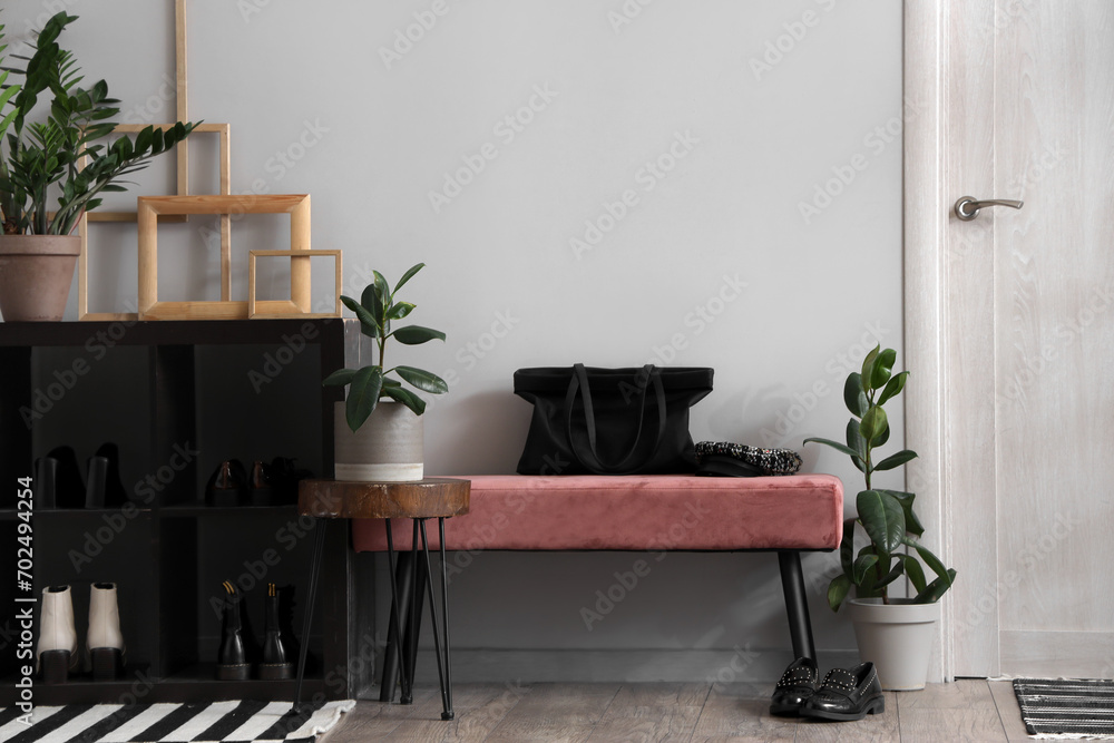 Interior of modern hallway with pink bench and houseplants