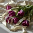bouquet of plum color tulips with cream ribbon on white background