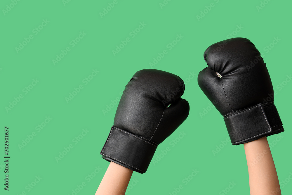 Female hands in boxing gloves on green background