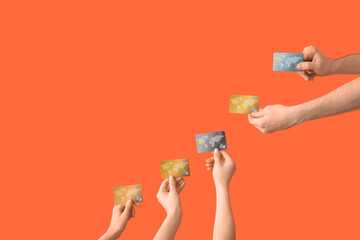 Wall Mural - Female hands with credit cards on orange background