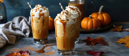 Canvas Print - Refreshing and festive fall drink made with iced pumpkin spice latte, topped with whipped cream and caramel sauce in tall glasses.