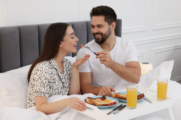 Sticker - Happy couple having breakfast on bed at home