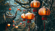 A group of orange lanterns hang on a pole in front of some trees