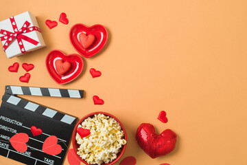 Happy Valentine's day and romantic movie concept with  movie clapper board, heart shapes and popcorn on trendy background. Top view, flat lay