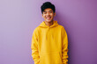 © Darya Lavinskaya - Asian happy teenage boy wearing yellow hoodie on purple background