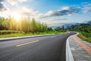 Wall Mural - Country road and green bamboo forest with mountain natural landscape at sunset