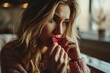 Beautiful blonde woman eating a valentine's day chocolate heart alone in the kitchen. Image for valentine's day, wedding, birthday or love message cards.