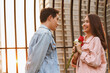 © gumpapa - young happy couple love and romantic at first date relationship. asian teenage woman surprise and smiling at boyfriend gives red rose flowers at dinner in valentine day. couple and happiness concept.