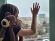 Girl child teenager at window pressing hands to window thoughtful or wanting to go out