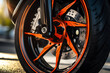 Close up of wheel of a sports car with orange brake disc.