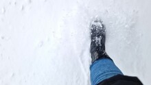 Women's feet walk through the snow in winter, first-person view. Close-up of human feet walking in the snow. Walk in winter