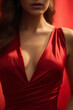 Cropped portrait of young beautiful brunette woman wearing red dress, on dark background. Deep neckline. Beauty and femininity. International Women's day. Part of face.