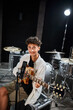 © LIGHTFIELD STUDIOS - cheerful talented teenage boy in casual outfit playing his guitar and looking at camera in studio