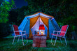 vintage cabin tent,  Antique oil lamp, retro chairs, Group of camping tents with outdoor coffee-making facilities on wooden tables in a forest camping area at night in the  forest