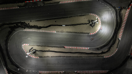Wall Mural - Aerial top view race kart track at night, Track for auto racing top view, Car race asphalt and curve street circuit, Aerial view asphalt race track at night.