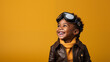 © Simon C - A cute black kid dressed as a pilot smiling at the camera on a plain yellow background