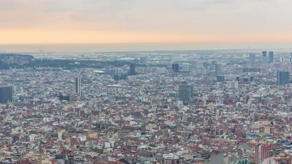 Wall Mural - Timelapse Panorama of Barcelona from the Bunkers of Carmel in Spain. Aerial Top View from Hill, Capturing the City Illuminated by Rays of Light on Cloudy Morning. The Sky in a Vibrant Array of Colors