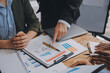 © Sutthicha - Co working conference, Business team meeting present, investor colleagues discussing new plan financial graph data on office table with laptop and digital tablet, Finance, accounting, investment.