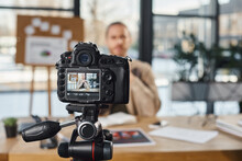 selective focus of professional digital camera near businessman recording video content in office