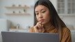 © Yuliia - Smart pensive Asian chinese woman 30s businesswoman work from home kitchen thoughtful writer think business plan contemplate search media online on laptop doubtful korean girl thinking idea decision