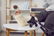 © Studio Romantic - Close-up photo of crutchers and a handicapped man's leg in cast on the chair in rehabilitation and recovering after having fractured limb. Selective focus. Recovery and rehab concept.