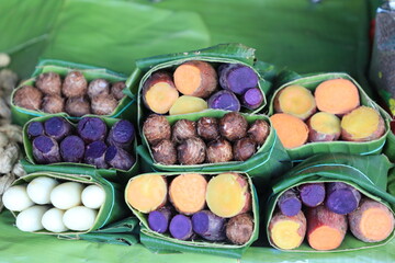 Group of waternut, chinese water chestnut, purple and yeloow sweet potato in banana leaf plate in the fresh market.