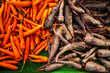 © Andrew Kornylak - A pile of freshly harvested orange and purple carrots in open shade at a farmers market in California