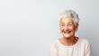 Portrait of a smiling senior woman on a white background. Gray-haired happy woman with short stitch and looking away and laughing happily. Copy space. The concept is a happy old age.