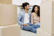 © MyJuly - happy young African American couple is moving new home. man and woman are sitting among cardboard boxes talking about mortgage or rental property. moving movers service. renewal of lease agreement