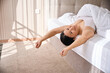 © Viacheslav Yakobchuk - Merry lady enjoying her morning wake-up in cozy bedchamber