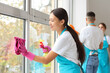 © Pixel-Shot - Female Asian janitor cleaning window in room