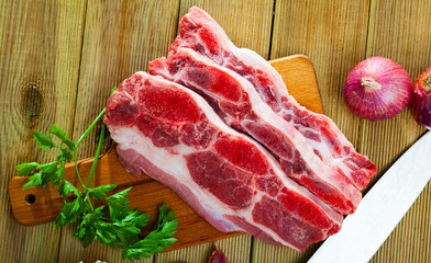 Poster - Raw beef with streaks of fat on kitchen table with red onion, garlic and parsley