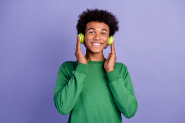 Poster - Photo of funny dreamy guy wear green pullover enjoying songs headphones isolated purple color background