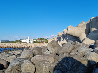 Canvas Print - Jeju Island beach with breakwater and basalt rocks.