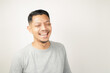 © Aria Armoko - Asian man expression with happy laughing face, isolated background