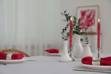 Wall Mural - Beautiful table setting with green branches in vases and burning candles indoors. Stylish dining room