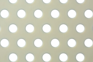 close-up macro view of plastic food strainer, abstract of beige color surface with round holes, mesh of holes or perforated wallpaper background