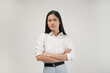 © Illhamt - A young Asian woman with folded arms and a stern expression looks directly ahead, reflecting seriousness and authority in a professional indoor setting