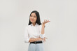 © Illhamt - A young Asian woman shrugs with both hands raised, expressing confusion or uncertainty in an office-like setting with a white background during the day