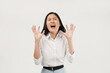 © Illhamt - An Asian woman in white is screaming with eyes closed and hands raised indoors in a white background setting, expressing overwhelming emotions in a professional context.