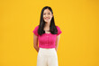 © Illhamt - Photo of asian woman in pink shirt, smiling and looking happy, standing over yellow background